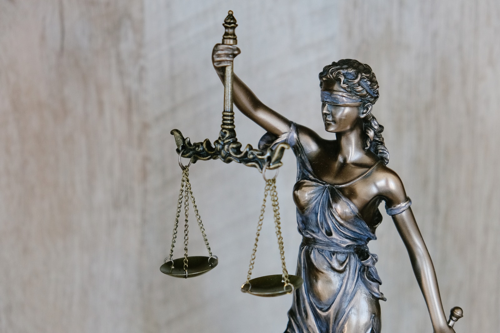Photo par Tingey Injury Law Firm woman holding sword statue during daytime